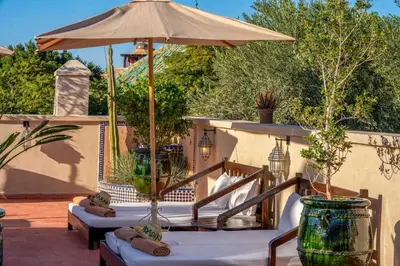 a patio with two chairs and an umbrella at Riad Adika & Spa in Marrakech
