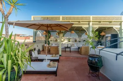 a patio with an umbrella and tables and chairs at Riad Adika & Spa in Marrakech