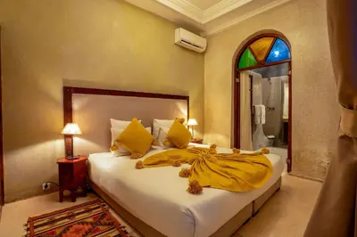 a bedroom with a bed with yellow sheets and a window at Riad Adika & Spa in Marrakech