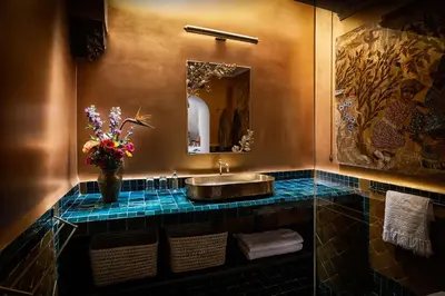 a bathroom with a sink and a vase of flowers at Riad Kbour & Chou in Marrakech