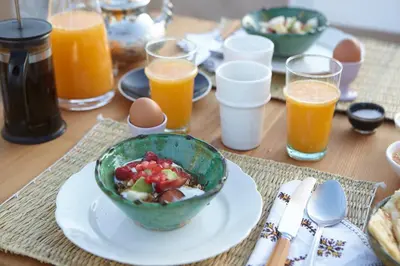a table with a bowl of food and glasses of orange juice at Riad Kbour & Chou in Marrakech