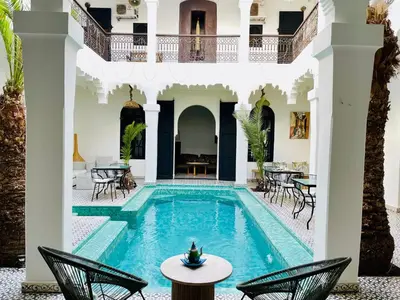a pool in a house with chairs and tables at Riad Fabiola Et Spa By La Siredrah in Marrakech