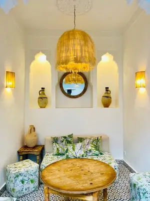 a room with a table and a chandelier at Riad Fabiola Et Spa By La Siredrah in Marrakech