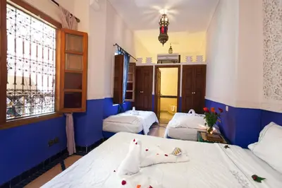 a room with two beds and a window at Riad Zanzibar in Marrakech