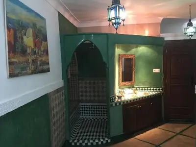 a room with a green wall and a mirror at Riad Zanzibar in Marrakech