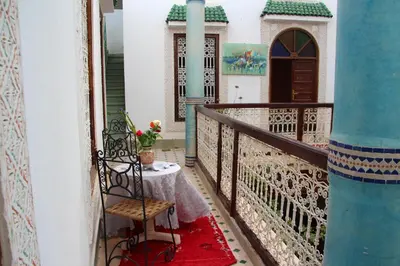 a balcony with a table and a chair at Riad Bibtia in Marrakech