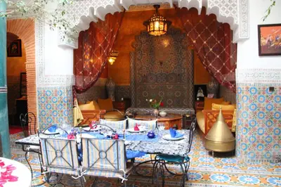 a dining room with tables and chairs in a building at Riad Bibtia in Marrakech