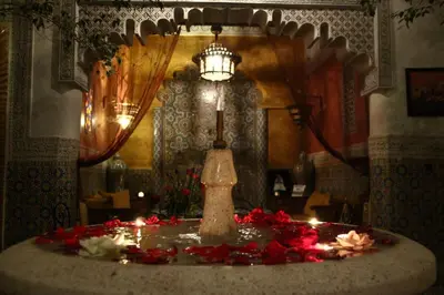 a room with a table with candles and a lamp at Riad Bibtia in Marrakech