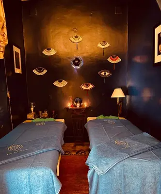 two beds in a room with umbrellas on the wall at Riad Dar Al Assad in Marrakech