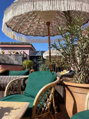 a patio with a table and chairs and an umbrella at Riad Dar Al Assad in Marrakech