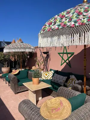 a patio with couches and a table and an umbrella at Riad Dar Al Assad in Marrakech