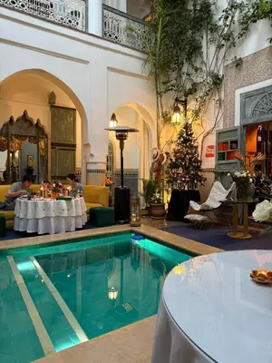 a hotel lobby with a swimming pool and a christmas tree at Riad Dar Al Assad in Marrakech