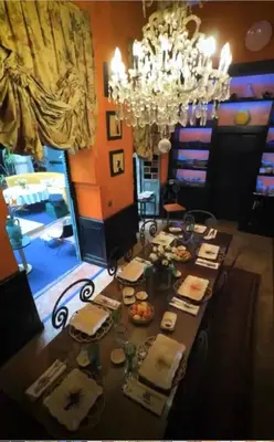 a dining room with a table with food and a chandelier at Riad Dar Al Assad in Marrakech