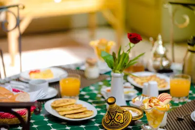 a table topped with plates of food and orange juice at Riad Amina in Marrakech