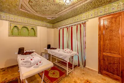 a room with two tables and a ceiling at Riad Amina in Marrakech