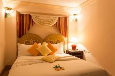 a bedroom with a large white bed with orange pillows at Riad Amina in Marrakech