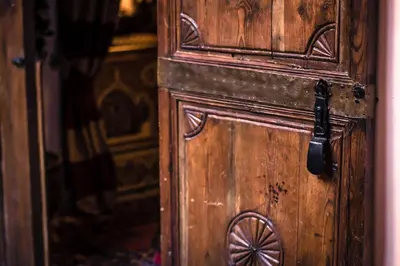 an old wooden door with a wheel on it at Riad Amina in Marrakech