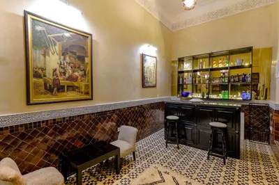 a bar with a couch and chairs in a room at Riad Amina in Marrakech