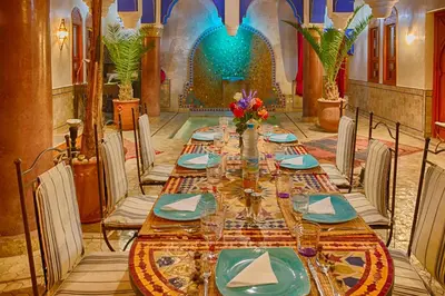 a long table in a room with chairs and a tableablish at Riad Kenzo in Marrakech