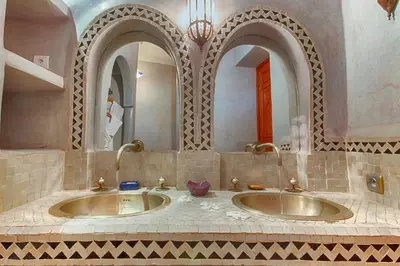a bathroom with two sinks and two mirrors at Riad Kenzo in Marrakech