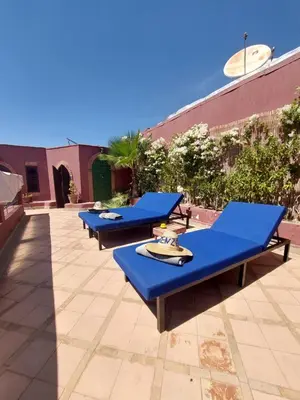 a row of blue picnic tables on a patio at Riad Kenzo in Marrakech