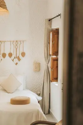 a bedroom with a bed and a window and atained at Riad Dar Coram in Marrakech