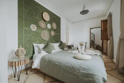 a bedroom with a bed with a green wall at Riad Dar Coram in Marrakech
