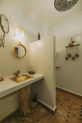 a bathroom with a sink and a mirror on the wall at Riad Dar Coram in Marrakech