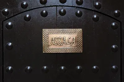 a black door with a gold plaque on it at Riad Assala in Marrakech