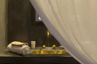 a bathroom sink with a towel on a counter at Riad Assala in Marrakech