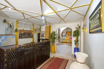 a living room with a dining room with a ceiling at Riad El Kennaria in Marrakech