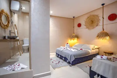 a bedroom with a bed and a bathroom with a toilet at Riad El Kennaria in Marrakech