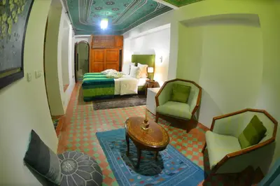a hotel room with a bed and a table and chairs at Riad Hidden in Marrakech