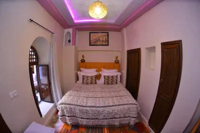 a bedroom with a bed with a purple ceiling at Riad Hidden in Marrakech