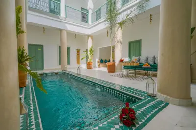 a large swimming pool in a room with a house at Riad Trésor in Marrakech