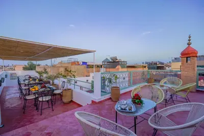 a patio with tables and chairs on a balcony at Riad Trésor in Marrakech