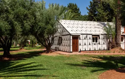 an old black and white barn with trees at Villa Des 3 Golfs in Marrakech