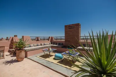 a patio with a couch and a table and plants at Villa Nelya in Marrakech