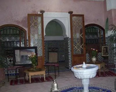 a living room with a fireplace and a sink in it at Riad Essaoussan in Marrakech