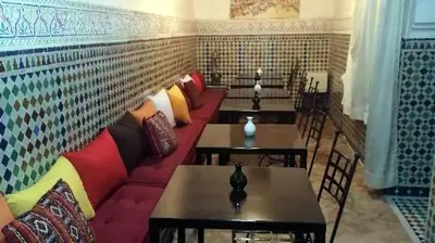 a living room with a red couch and tables at Riad Essaoussan in Marrakech