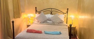 a bedroom with a bed with two towels on it at Riad Essaoussan in Marrakech
