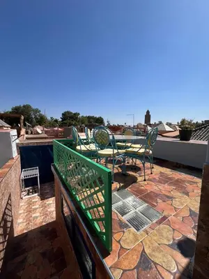 a patio with chairs and tables on a roof at Riad Noureddine in Marrakech