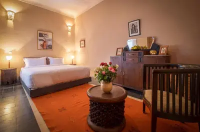 a bedroom with a bed and a table with flowers on it at Riad Adrar in Marrakech
