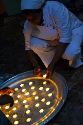 a woman is lighting up a metal tray with lights at Dar Crystal in Marrakech