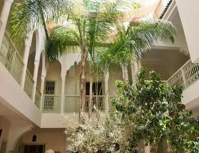 a building with palm trees in the courtyard at Dar Crystal in Marrakech