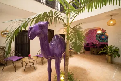 a purple horse statue next to a palm tree at Riad Houdou in Marrakech