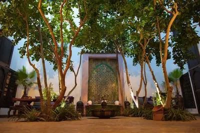 a building with a wall with trees in front of it at Riad Houdou in Marrakech