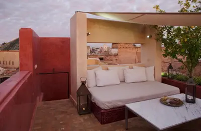 a bed on top of a balcony with a table at P´tit Habibi in Marrakech