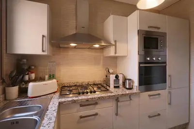 a kitchen with white cabinets and a stove top oven at golf city Av Med VI in Marrakech