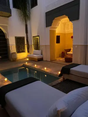 a hotel room with a swimming pool with two beds at Riad Hadika Maria in Marrakech